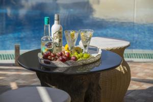 un vassoio di frutta e bottiglie di vino su un tavolo di Ayia Napa Tropical Beach Villa a Ayia Napa