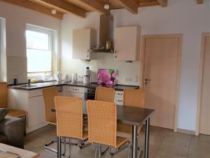 a kitchen with a table and chairs in a room at Urlaubsreif-Rügen in Glowe