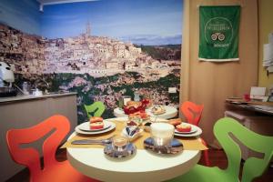 una mesa con comida en ella con una pintura de una ciudad en I Tre Fiori, en Matera