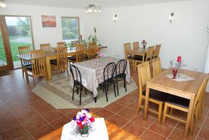 comedor con mesas y sillas de madera en Algallika Guesthouse, en Kukeranna