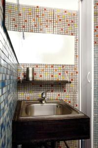 a bathroom with a sink and a tiled wall at Solsicily in Catania