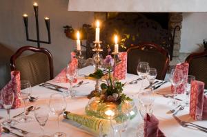 a table with candles and wine glasses on it at Landgasthof Eschbacher Katz in Usingen