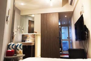 Schlafzimmer mit einem Bett, einem Waschbecken und einem Spiegel in der Unterkunft Gathering in Kaohsiung