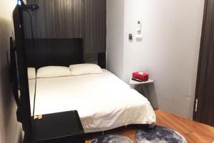 1 dormitorio con cama blanca y cabecero negro en Gathering, en Kaohsiung