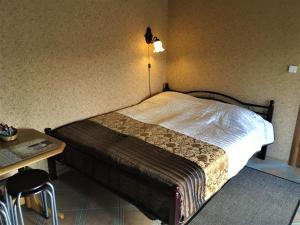 um quarto com uma cama, uma mesa e um candeeiro em Jūra em Ventspils