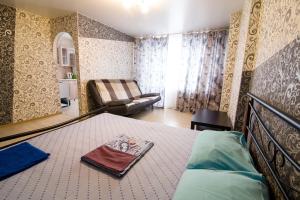 um quarto com uma cama e um sofá em Пионерский,46 em Novokuznetsk