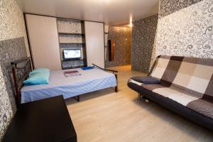 ノヴォクズネツクにあるПионерский,46のベッド1台とソファが備わる小さな客室です。