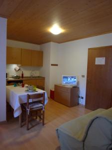 a living room with a table and a kitchen at Appartamento San Marco in Caprile