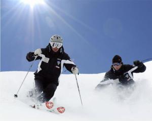 two people are skiing down a snow covered slope at Appartamento San Marco in Caprile
