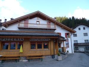 a restaurant with benches in front of a building at Appartamento San Marco in Caprile +23 photos