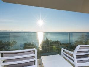 2 sillas blancas en un balcón con vistas al océano en Luxurious Villa in Kozino with Fenced Garden, en Kožino