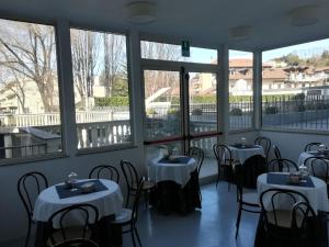 Hotel Ponte Sassi في تورينو: غرفة بها طاولات وكراسي ونوافذ