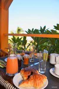 una mesa con un plato de cruasanes y zumo de naranja en Poz Lagon en La Saline les Bains