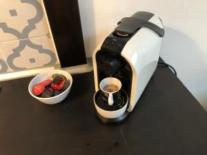 a coffee maker sitting on a counter next to a cup of coffee at Dunakavics Boutique Apartman Szentendre in Szentendre