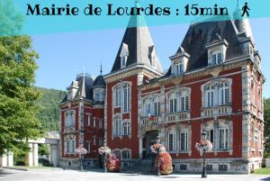 un gran edificio rojo con dos osos delante en PARENTHESE - Le Marqui, en Lourdes