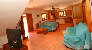 un salon avec des chaises bleues et une télévision dans l'établissement Can Toni, à Campos