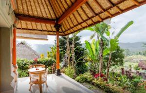 a porch with a table and chairs and a view at Lila Stana - Sidemen Homestay in Sidemen