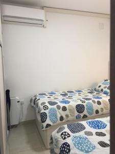 a bedroom with two beds with blue and white sheets at First line Apartment in Alicante