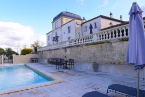 uma casa com piscina e guarda-sol em Chateau de Lantic em Martillac