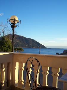 a chair sitting on a balcony overlooking the ocean at Hotel La Giara in Recco