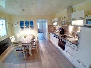 a kitchen with a table and a dining room at Ferienwohnung Deichstr De Lorenzo in Carolinensiel
