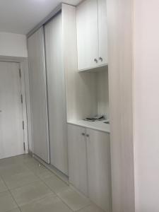 a white kitchen with white cabinets and a door at First line Apartment in Alicante