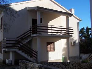 a white house with stairs on the side of it at Apartments Šestan in Novalja