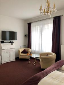 um quarto de hotel com uma cama e um lustre em Hotel Sylter Blaumuschel em Westerland