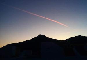 a jet trail in the sky over a mountain at Casa Nettuno Favignana in Favignana