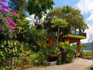 a house with a lot of flowers in front of it at Dajan Buyan Homestay in Bedugul