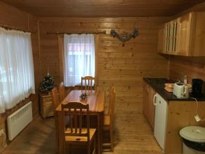 eine Küche und ein Esszimmer mit einem Tisch und Stühlen in der Unterkunft Chalet Sofia in Borowez