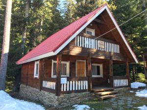 Cabaña de madera pequeña con techo rojo en Chalet Sofia, en Borovets