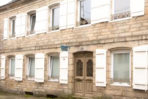 an old brick building with a door and windows at Les Chambres de Lourmel in Pontivy