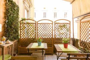 2 mesas y sillas en un patio con plantas en Relais Calamatta, en Roma