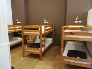 a room with three bunk beds in it at Albergue Ultreia in Arzúa