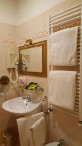a bathroom with a sink and a mirror and towels at Hotel Locanda Canal in Venice
