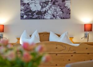バート・ビルンバッハにあるHaus im Mosergartenのベッドルーム1室(白い枕と花のベッド付)