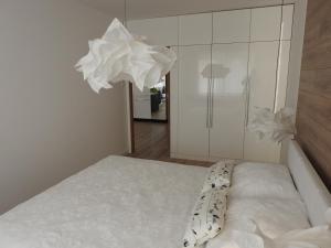 sypialnia z łóżkiem i białą szafką w obiekcie Apartament z ogrodem Wiśniowy Sad w Kołobrzegu