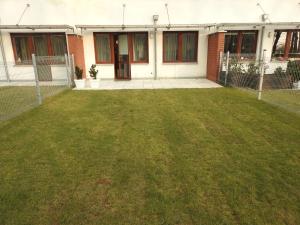 an empty yard in front of a house at Apartament z ogrodem Wiśniowy Sad in Kołobrzeg