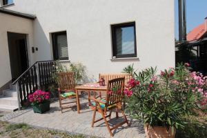 een tafel en 2 stoelen op een patio met bloemen bij Ferienwohnung Frenkel in Freital