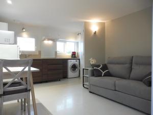 a living room with a couch and a kitchen at Villa Cathy T2 in Aix-les-Bains