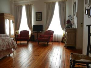 サン・ジャン・ダンジェリにあるLa Maison de l'Ambassadeurのベッドルーム1室(椅子2脚、ベッド1台、窓2つ付)