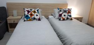 two twin beds in a hotel room with pillows at Sunny Napa Apartments in Ayia Napa +28 photos