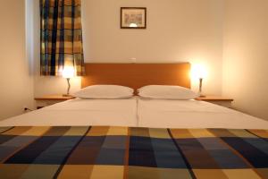 a bedroom with a large bed with two lamps at Apartments Ivana in Baška Voda +60 photos