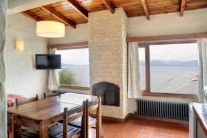 a dining room with a table and a fireplace at Bungalows La Caleta D.T. 026/17 in San Carlos de Bariloche