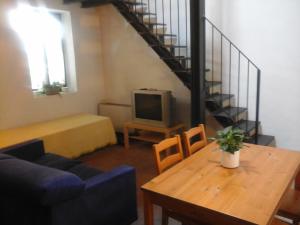 a living room with a couch and a table and a staircase at Agriturismo Cascina Rossano in Provaglio d'Iseo