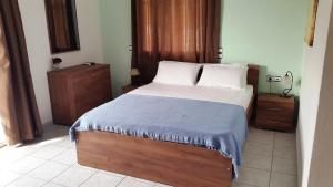 a bedroom with a large bed with a blue blanket at Galini Apartments in Plakias