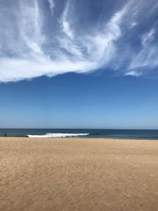 a beach with a cloudy sky and the ocean at La Casita del Puente in La Pedrera