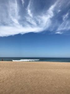 una playa con un cielo nublado y el océano en La Casita del Puente, en La Pedrera