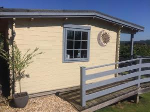 a small house with a window and a porch at Morlais Log Cabin in Lyme Regis
